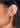 Close-up of an ear wearing a gold earring with red gemstones. Garnet Gesmtone Jewellery